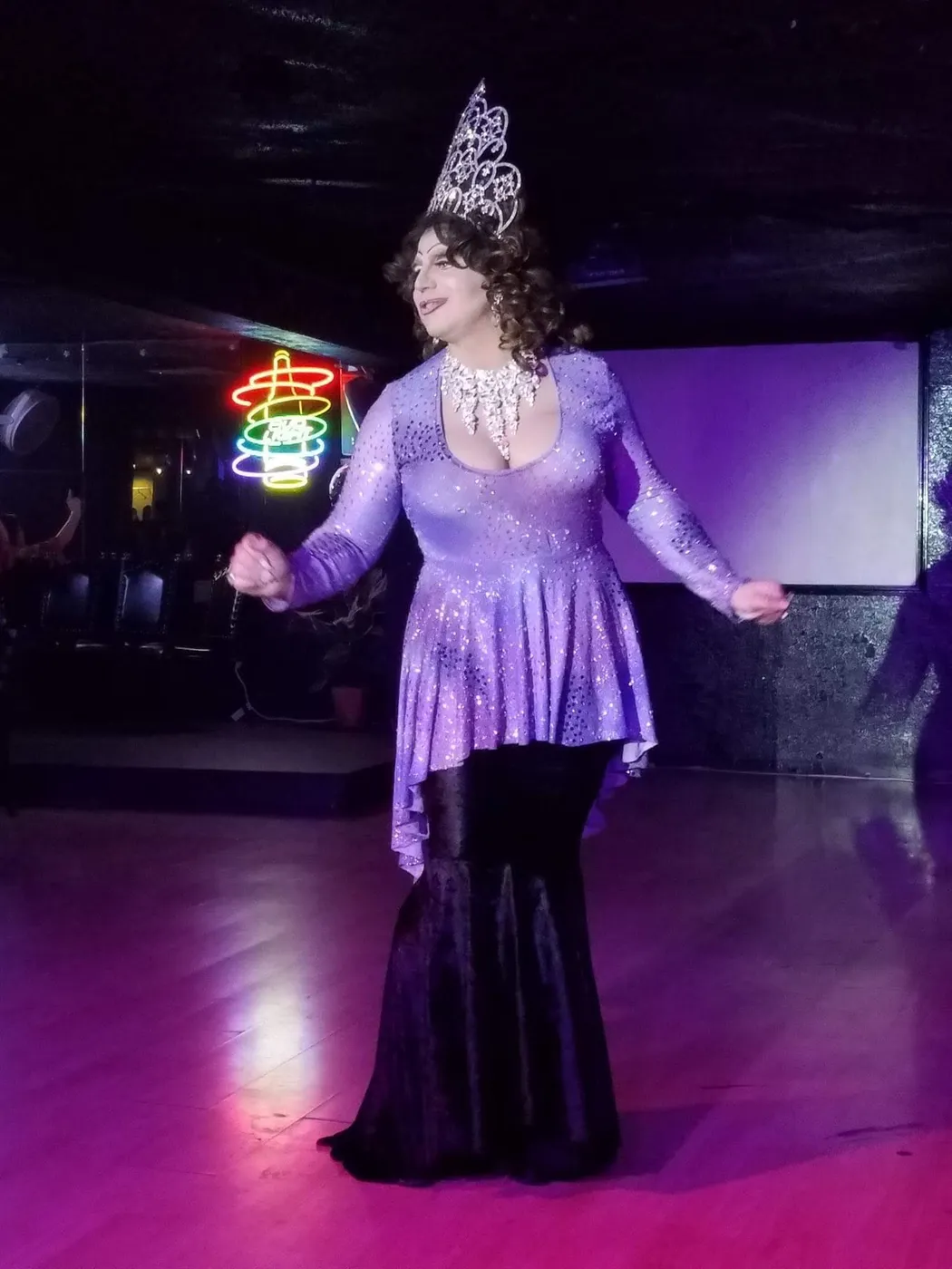 Divinity Masters performing on stage in a lavender gown and tiara